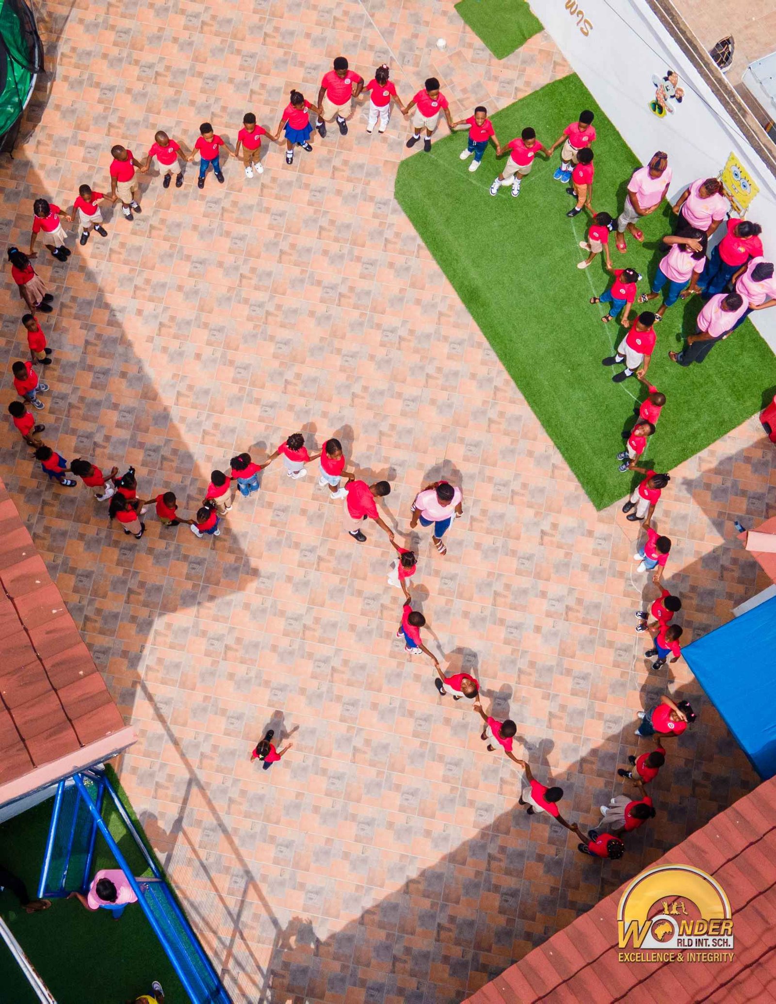 Students forming a hand-in-hand chain across the courtyard